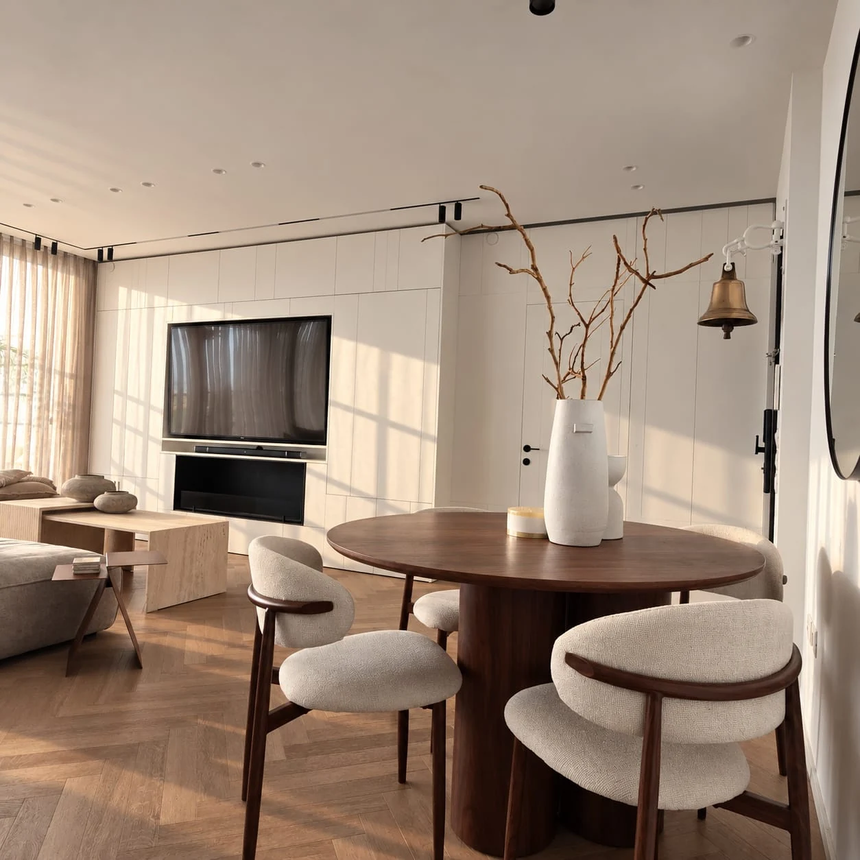 Dining table, upholstered chairs and television wall within the shared space