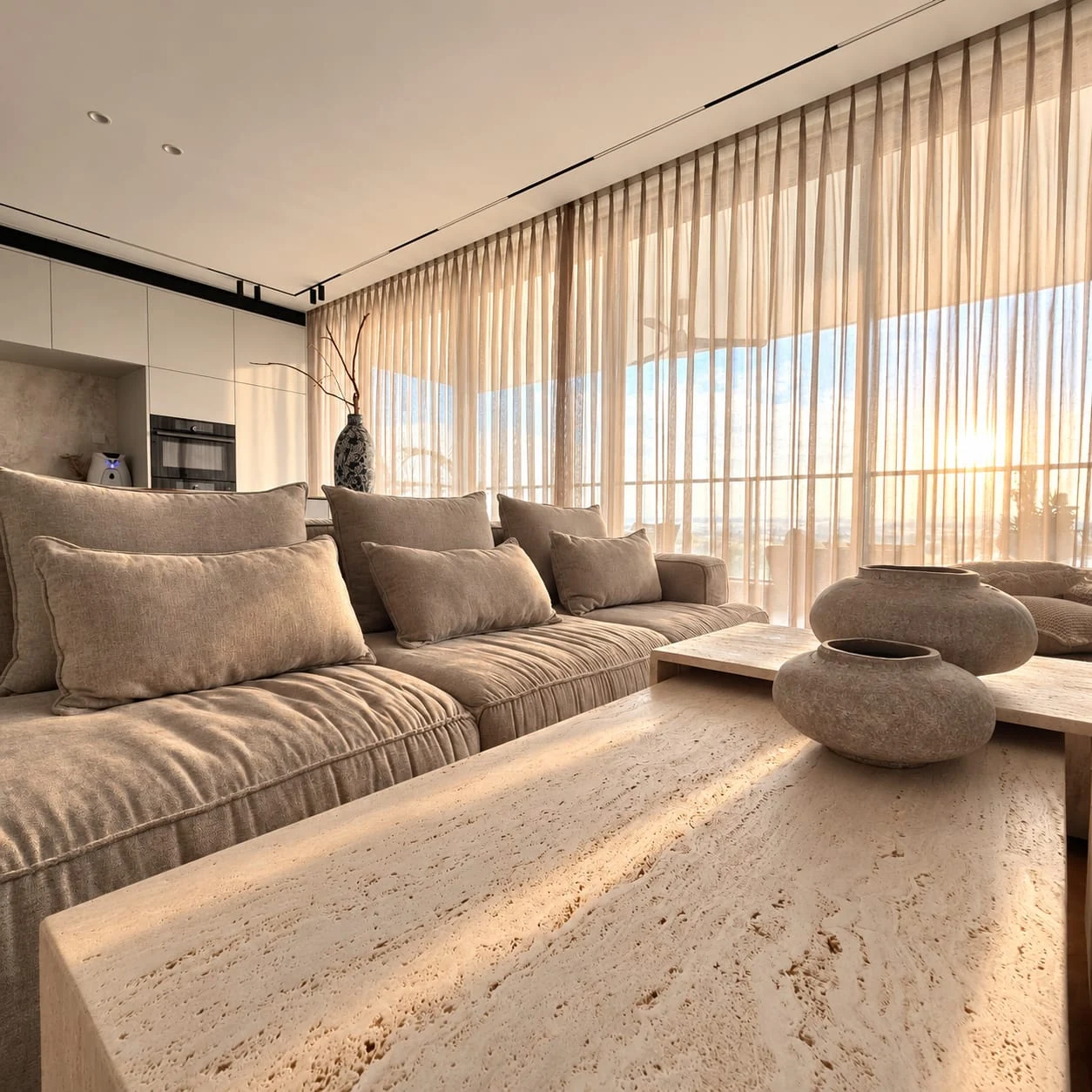 Sofa corner and pale tables facing the television wall