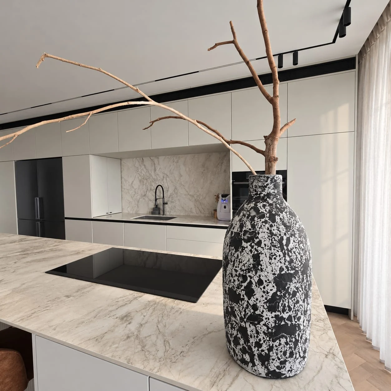 Hob and vase on the island facing the sink and kitchen niche