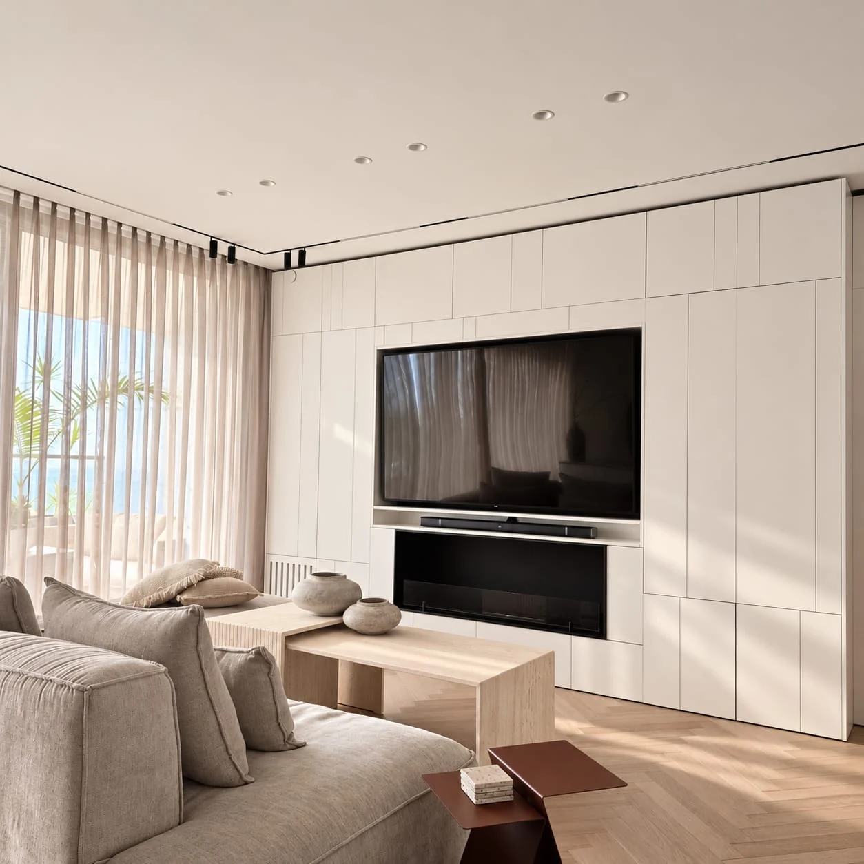 Wide view from the sofa towards the television wall, window and cabinetry