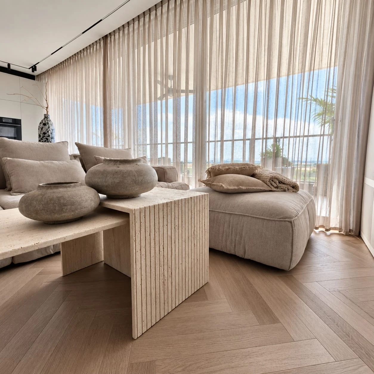 Table with a ribbed end between sofa sections beside the window
