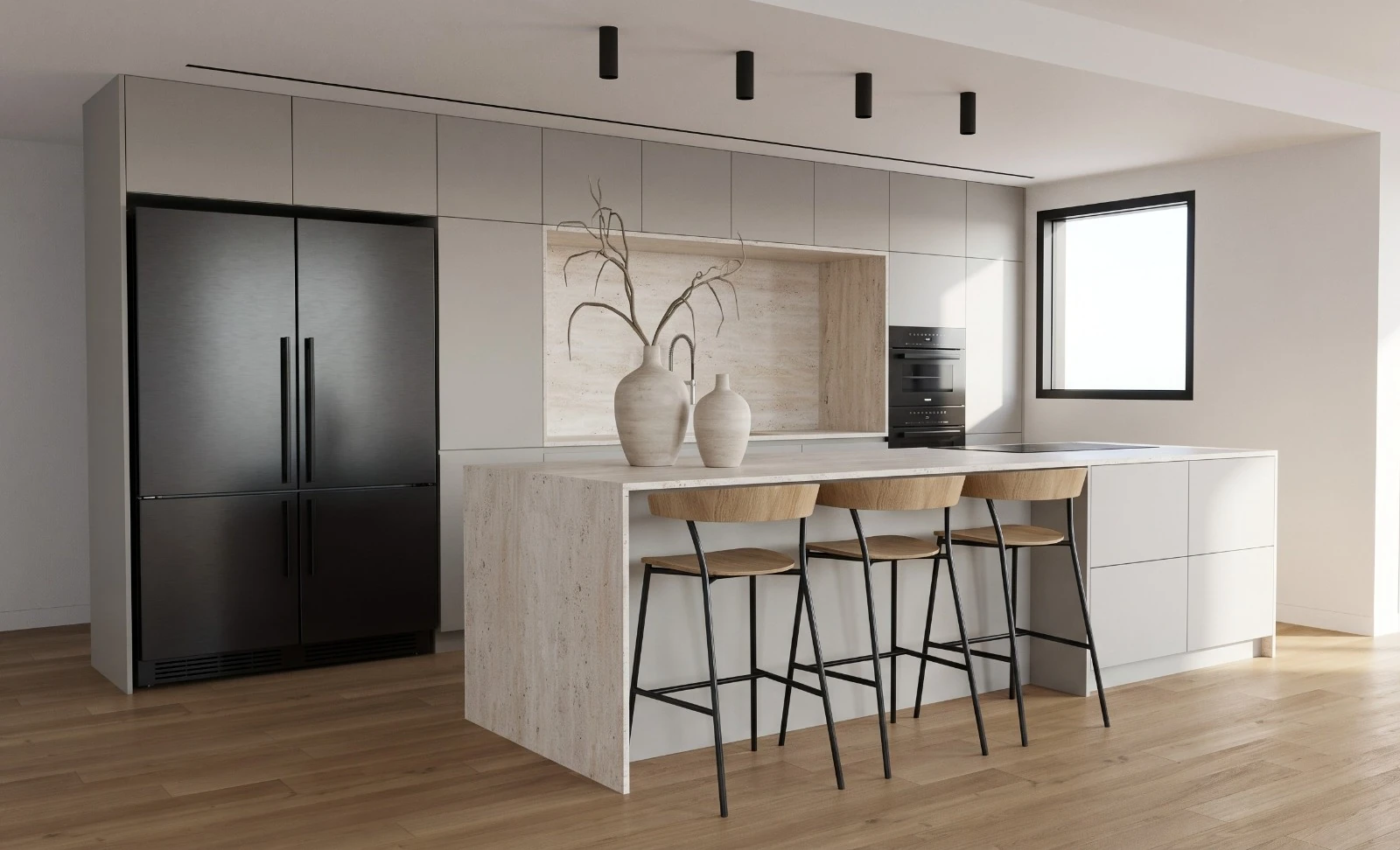 Gray kitchen and stone island viewed at an angle, with a dark refrigerator and wooden stools.